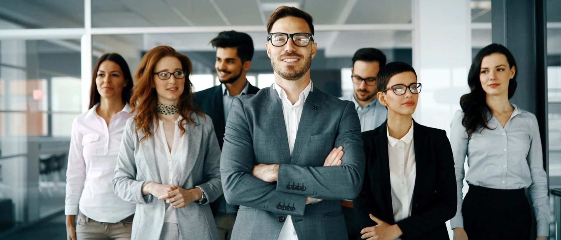 Office workers in a modern lobby full length group portrait